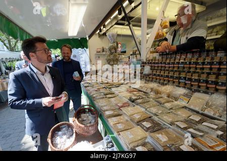 28. April 2022, Nordrhein-Westfalen, Köln: Thomas Kutschaty, Spitzenkandidat der SPD für die Landtagswahl in Nordrhein-Westfalen, verteilt Werbematerial auf einem Markt in Leverkusen-Opladen. Im Hintergrund ist der Bürgermeister von Leverkusen, Uwe Richrath, zu sehen. (To dpa 'Frikadelle mit Kakao - wie Wüst und Kutschaty Wahlkampf machen') Foto: Henning Kaiser/dpa Stockfoto