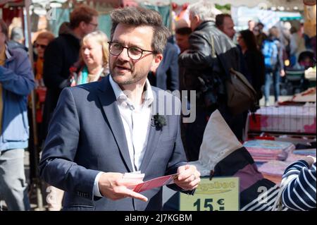 28. April 2022, Nordrhein-Westfalen, Köln: Thomas Kutschaty, Spitzenkandidat der SPD für die Landtagswahl in Nordrhein-Westfalen, verteilt Werbematerial auf einem Markt in Leverkusen-Opladen. (To dpa 'Frikadelle mit Kakao - wie Wüst und Kutschaty Wahlkampf machen') Foto: Henning Kaiser/dpa Stockfoto