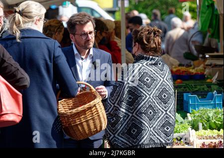 28. April 2022, Nordrhein-Westfalen, Köln: Thomas Kutschaty, Spitzenkandidat der SPD für die Landtagswahl in Nordrhein-Westfalen, verteilt Werbematerial auf einem Markt in Leverkusen-Opladen. (To dpa 'Frikadelle mit Kakao - wie Wüst und Kutschaty Wahlkampf machen') Foto: Henning Kaiser/dpa Stockfoto