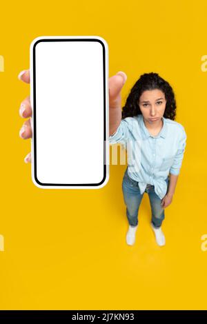 Traurige Dame mit leerem Smartphone-Bildschirm Stockfoto