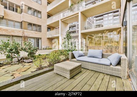 Komfortable Sofas mit Kissen auf der Terrasse eines modernen Wohngebäudes Stockfoto