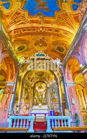 MORCOTE, SCHWEIZ - 25. MÄRZ 2022: Der Altar der mittelalterlichen Kirche San Rocco, geschmückt mit bunten Fresken, am 25. März in Morcote Stockfoto