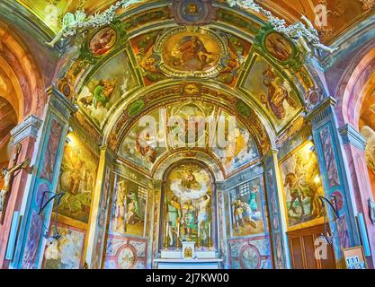 MORCOTE, SCHWEIZ - 25. MÄRZ 2022: Der Altar der mittelalterlichen Kirche San Rocco mit Fresken der Heiligen, am 25. März in Morcote Stockfoto