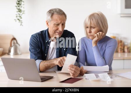 Traurige ältere Ehemann und Ehefrau überprüfen ihre Ausgaben Stockfoto