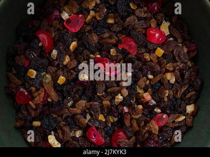 Flache Lay Zusammensetzung aus getrockneten Früchten, glaće Kirschen und kandierten Schale in einer grünen Rührschüssel. Stockfoto
