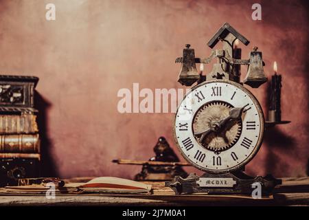 Vintage-Tapete mit Kopierbereich. Antiker Schreibtisch mit Uhr, Tintenfass und Stift. Stockfoto