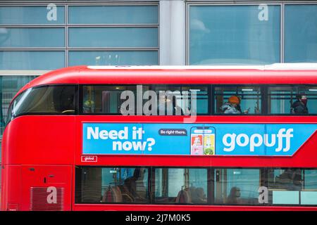 Passagiere, einige tragen eine Maske, andere nicht, werden in einem Doppeldeckerbus in der City of London gesehen. Stockfoto