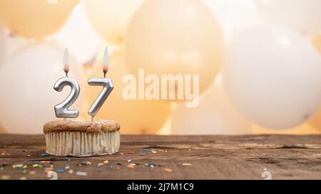 Happy Birthday Karte mit einer Kerze in einem Cupcake vor dem Hintergrund von Ballons. Kopieren Raum Happy Birthday mit Cupcake-Ziffer Stockfoto