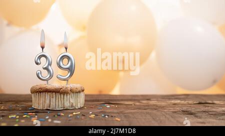 Happy Birthday Karte mit einer Kerze in einem Cupcake vor dem Hintergrund von Ballons. Kopieren Raum Happy Birthday mit Cupcake-Ziffer Stockfoto