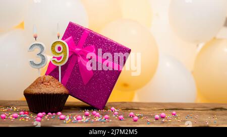 Alles gute zum Geburtstag mit rosa Geschenkbox für Baby Mädchen. Schöne Geburtstagskarte mit einem Cupcake und einer brennenden Kerze Stockfoto