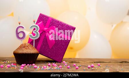 Alles gute zum Geburtstag mit rosa Geschenkbox für Baby Mädchen. Schöne Geburtstagskarte mit einem Cupcake und einer brennenden Kerze Stockfoto