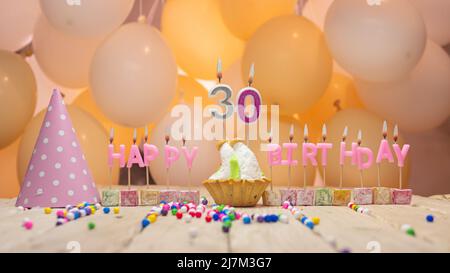 Schöner Hintergrund Happy Birthday Nummer mit brennenden Kerzen, Geburtstagskerzen in rosa Buchstaben. Festlicher Hintergrund mit Ballons Stockfoto