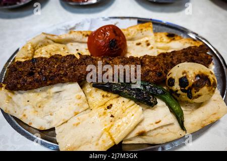 Adana Kebab, traditionelle türkische Küche mit Kebab-Fleisch, Gemüse auf dem Teller in Adana, Türkei Stockfoto