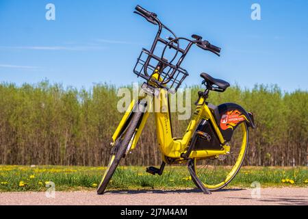 Minsk, Weißrussland - 10. Mai 2022: Ein gelbes Sharing-Fahrrad wartet auf jemanden, der es ausleihen kann Stockfoto