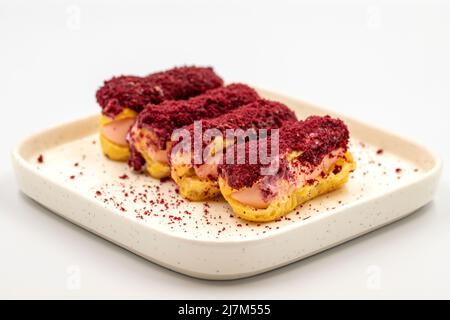 Himbeer-eclair-Kuchen. Eclair-Kuchen mit Himbeerfüllung auf weißem Hintergrund. Nahaufnahme Stockfoto