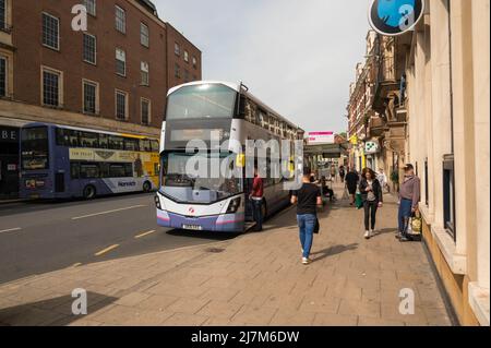 Bushaltestelle im Stadtzentrum von Norwich mit einem Mann, der auf einen Doppeldeckerbus wartet Stockfoto