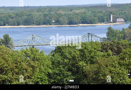 10. Mai 2022, Brandenburg, Potsdam/Babelsberg: Blick auf die Glienicker Brücke vom Flatow-Turm im Park Babelsberg; im Hintergrund ist die Krähenkirche zu sehen. In den kommenden Jahren soll in der Reihe 'Denkmaltopographie Bundesrepublik Deutschland' ein mehrbändiger Katalog zu Potsdam erscheinen. Das Projekt wird unter der Leitung des Landesamtes für Denkmalpflege Brandenburg (BLDAM) in Zusammenarbeit mit der Schlossstiftung (SPSG) und der Stadt entwickelt. Foto: Bernd Settnik/dpa/ZB Stockfoto