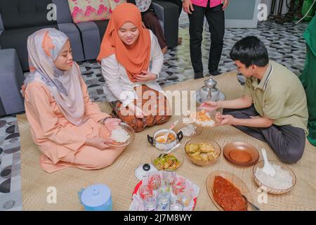 Batu Pahat, Malaysia - 4.. Mai 2022: Eine Familie Hari Raya Aidilfitri Eid-UL-Fitr Essen und eine Festlichkeit in Malaysia Familie, Glück und Vergebung Stockfoto