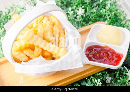 Die frisch gebratenen pommes frites mit Ketchup und weißer Sauce Stockfoto