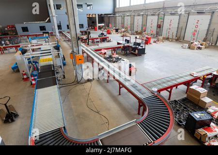 Große Sicht auf leeres Förderband mit Kartons und Möbeln im Distributionslager Stockfoto