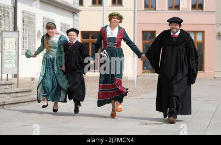 Lutherstadt Wittenberg, Deutschland. 10.. Mai 2022. Jasmin Fröse (l-r), Mika Förster, Nicole Melzer-Fricke und Frank Moritz, Performer des Lutherpaares und des Lutherpaares der Kinder beim Wittenberger Stadtfest „Lutherhochzeit“, gehen über den Marktplatz. Das Festival, das vom 10. Bis 12. Juni 2022 stattfindet, erinnert an die Hochzeit des ehemaligen Mönchs Martin Luther mit der Nonne Katharina von Bora im Jahr 1525. Jedes Jahr im Juni feiern Wittenberger und ihre Gäste dieses Fest als ihr großes Fest. Kredit: Sebastian Willnow/dpa/Alamy Live Nachrichten Stockfoto