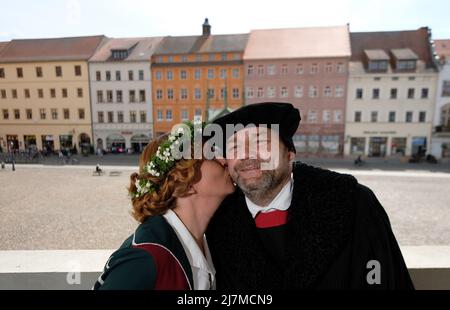 Lutherstadt Wittenberg, Deutschland. 10.. Mai 2022. Auf dem Balkon des Rathauses stehen Nicole Melzer-Fricke und Frank Moritz, Interpreten des Ehepaares Luther für das Wittenberger Stadtfest „Luthers Hochzeit“. Das Festival, das vom 10. Bis 12. Juni 2022 stattfindet, erinnert an die Hochzeit des ehemaligen Mönchs Martin Luther mit der Nonne Katharina von Bora im Jahr 1525. Jedes Jahr im Juni feiern Wittenberger und ihre Gäste dieses Fest als ihr großes Fest. Kredit: Sebastian Willnow/dpa/Alamy Live Nachrichten Stockfoto