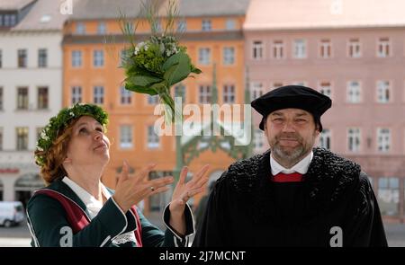 Lutherstadt Wittenberg, Deutschland. 10.. Mai 2022. Auf dem Balkon des Rathauses stehen Nicole Melzer-Fricke und Frank Moritz, Interpreten des Ehepaares Luther für das Wittenberger Stadtfest „Luthers Hochzeit“. Das Festival, das vom 10. Bis 12. Juni 2022 stattfindet, erinnert an die Hochzeit des ehemaligen Mönchs Martin Luther mit der Nonne Katharina von Bora im Jahr 1525. Jedes Jahr im Juni feiern Wittenberger und ihre Gäste dieses Fest als ihr großes Fest. Kredit: Sebastian Willnow/dpa/Alamy Live Nachrichten Stockfoto