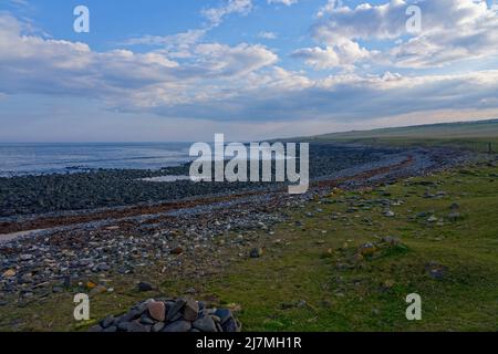 Niedrige Wolken und Nebel hängen über der felsigen, geschwungenen Küste in der Nähe von Craster, Northumbria. Stockfoto