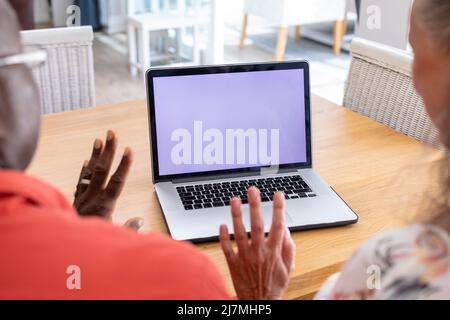 Multirassisches Senior-Paar, das während eines Videoanrufs die Hände an den Laptop schwenkt, Platz kopieren. Unverändert, Lebensstil, Ruhestand, Zweisamkeit, Wireless-Technologie, o Stockfoto