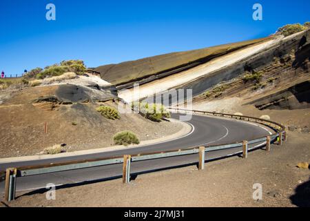 Auf dem Weg nach Praque Nacional del Teide stapeln sich verschiedene vulkanische Strömungen in verschiedenen und auffallenden Farben, die die Einheimischen als La Tarta kennen. Stockfoto