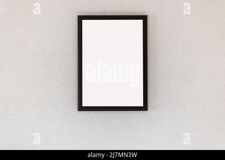 Leerer Bilderrahmen, der an einer weißen Wand im Zimmer hängt Stockfoto