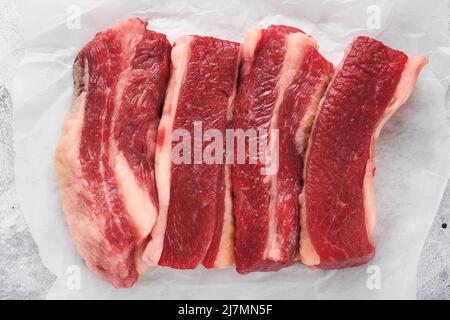 Rindersteak. Rohes Steak New York mit Rosmarin und Gewürzen auf einem Stück Pergamentpapier Draufsicht. Modell. Stockfoto