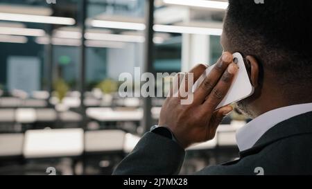 Afroamerikanischer Mann zuversichtlich Geschäftsmann Teamleiter Manager Anruf Geschäftspartner kommunizieren mit Freund sprechen auf dem Smartphone Diskutieren entfernt Stockfoto