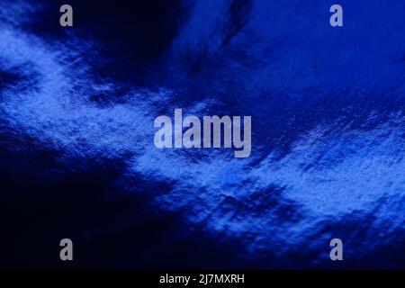 Satter dunkelblauer glänzender Hintergrund. Indigo-Farbe. Ajna Chakra oder dritte Augenschattenfarbe. Stockfoto