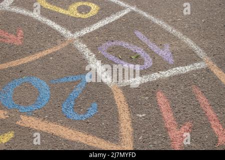 Auf dem Asphalt wird im Hof neben einem Haus in der Ukraine ein Kinderspiel mit Zahlen gezeichnet, auf der Straße ein Kinderspiel Stockfoto