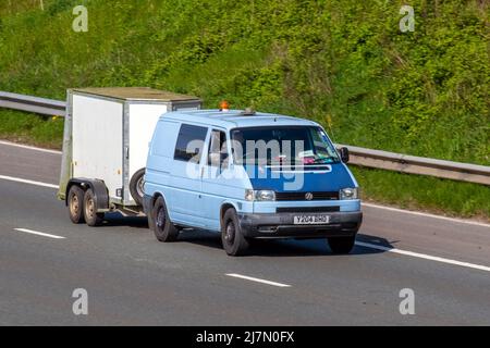 2001 blauer VW Volkswagen Transporter TDI Syncro SW 102 4WD SWB LVC Kastenwagen, der einen Anhänger schleppt. 1200 Special P/V 2461cc Diesel Schaltgetriebe; Fahren auf dem M61 in Manchester, Großbritannien Stockfoto