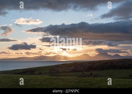 Fabelhafter Sonnenuntergang in der Nähe von Kilberry Village in Argyll and Bute, mit crepuskulären Strahlen, die durch die schweren dunklen Wolken durchdringen, wunderschöne Dämmerung in Schottland Stockfoto