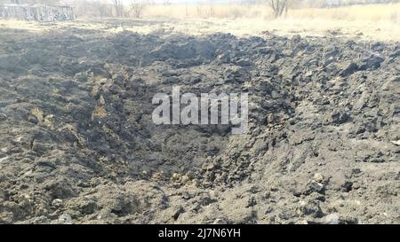 LYSYTSCHANSK, - UKRAINE 30. März 2022: Krieg Russlands gegen die Ukraine. Riesiges Loch im zivilen Garten von Bomben. Garten von Flugzeugen der russischen Armee beschädigt Stockfoto