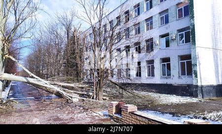 LYSYTSCHANSK, - UKRAINE 28. März 2022: Beschädigtes Bürogebäude und Bäume durch Artillerie der russischen Armee, Flugraketenbomben. Stockfoto