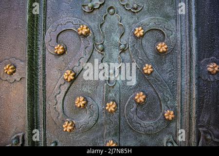 Nahaufnahme von acient grünen geschmiedeten Türen mit goldenen Sternen, tektonischer Hintergrund. Dominikanische Kirche in Lviv, Ukraine Stockfoto