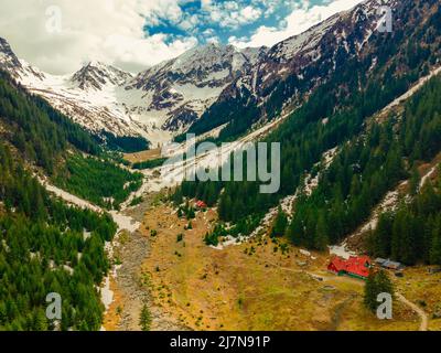 Panoramablick auf die Karpaten im Frühling, mit schneebedeckten Gipfeln. Die Fotografie wurde von einer Drohne in einer höheren Höhe aufgenommen. Stockfoto