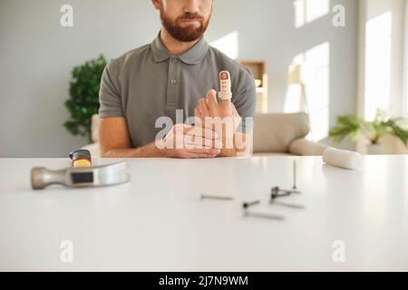 Verletzter Mann mit Schiene am Finger nach Hammerschlag Stockfoto