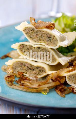 Hälften schwäbische maultaschen Pasta mit Salat Stockfoto