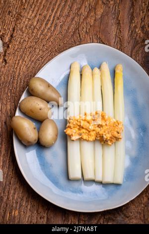 Weißer Spargel auf einem blauen Teller Stockfoto
