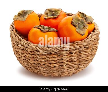 Persimmon in einem Weidenkorb Pfad isoliert auf weiß Stockfoto