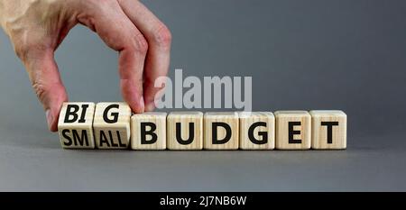 Großes oder kleines Budgetsymbol. Geschäftsmann dreht Holzwürfel und ändert Wörter kleines Budget zu großes Budget. Schöne graue Tabelle grauen Hintergrund, Kopie sp Stockfoto