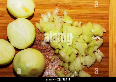 Frisch gehackte Zwiebel auf einem Holzschneidebrett. Stockfoto