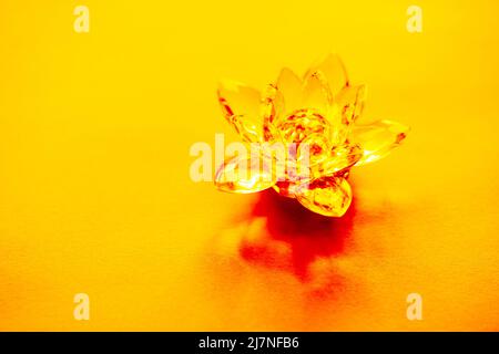 Kristalllotus auf gelbem Tisch. Symbol für das Manipulura-Chakra. Stockfoto