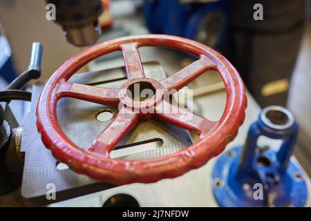 Nahaufnahme am Rohrleitungsarmatur, der zur Steuerung des Produktionsprozesses in der Ölraffinerie verwendet wird. Selektiver Fokus am Ventilgriff, Schweres in Stockfoto