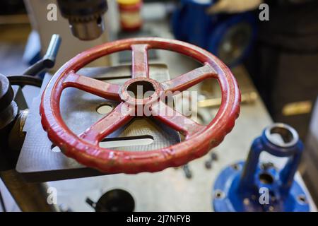 Nahaufnahme am Rohrleitungsarmatur, der zur Steuerung des Produktionsprozesses in der Ölraffinerie verwendet wird. Selektiver Fokus am Ventilgriff, Schweres in Stockfoto